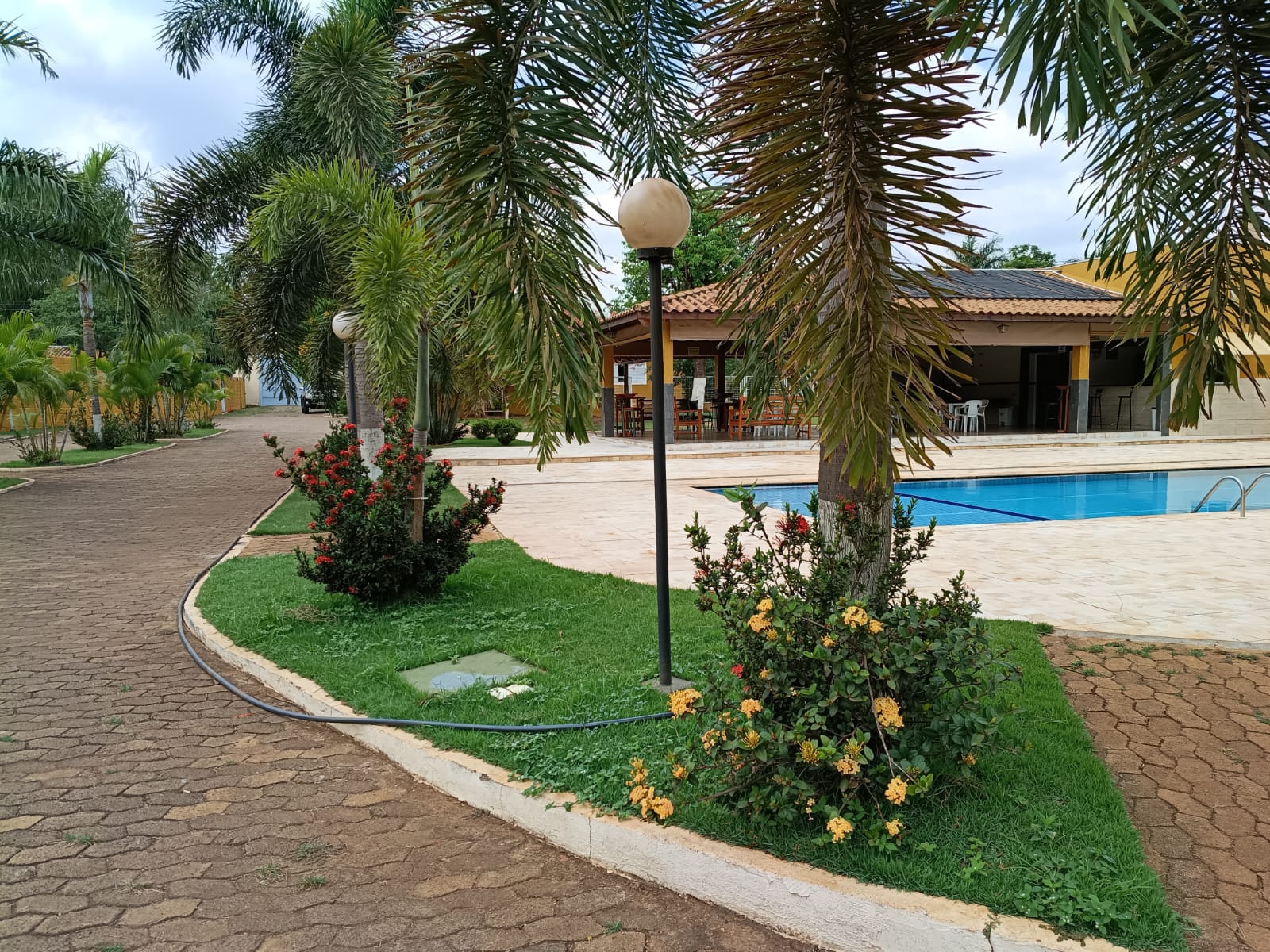 Entrada da área de piscina com palmeiras no Recanto